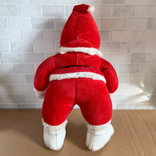 Load image into Gallery viewer, This rare adorable vintage mid-century era large rubber faced Santa Claus stuffed toy features a smiling side eyed face, a sheared velour red suit bordered with white plush trim, black vinyl belt, white velour hands, white vinyl-type blanket stitched boots. Crafted by the Rushton Company, USA, 1950s. A wonderful piece of Christmas nostalgia!

In as found vintage condition. The stitching on the boots have been repaired and could benefit from additional repair. Original tag.

Measures 13 1/2 x 24 1/2 inches

