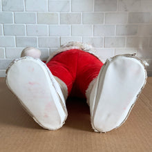 Load image into Gallery viewer, This rare adorable vintage mid-century era large rubber faced Santa Claus stuffed toy features a smiling side eyed face, a sheared velour red suit bordered with white plush trim, black vinyl belt, white velour hands, white vinyl-type blanket stitched boots. Crafted by the Rushton Company, USA, 1950s. A wonderful piece of Christmas nostalgia!

In as found vintage condition. The stitching on the boots have been repaired and could benefit from additional repair. Original tag.

Measures 13 1/2 x 24 1/2 inches
