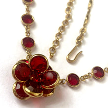 Load image into Gallery viewer, Close-up of faceted ruby red Swarovski crystal flower pendant in gold-tone setting showing precision cut and brilliant sparkle
