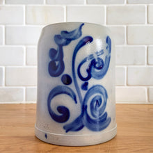 Load image into Gallery viewer, Salt glazed pottery has such a magical quality with its simple decorative style. This  tankard has a beautiful botanical design in cobalt blue which is striking against the light gray pottery. As a functional piece, it lends itself to many decor styles. This  tankard is perfect for a mug of beer or repurpose to hold a small grouping of kitchen utensils or use as a pen/pencil holder.  In excellent condition, no chips or cracks. Unmarked.  Measures 3 3/4 x 5 inches  Capacity 1/2 litre   

