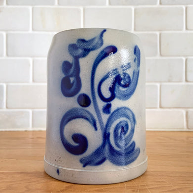 Salt glazed pottery has such a magical quality with its simple decorative style. This  tankard has a beautiful botanical design in cobalt blue which is striking against the light gray pottery. As a functional piece, it lends itself to many decor styles. This  tankard is perfect for a mug of beer or repurpose to hold a small grouping of kitchen utensils or use as a pen/pencil holder.  In excellent condition, no chips or cracks. Unmarked.  Measures 3 3/4 x 5 inches  Capacity 1/2 litre   