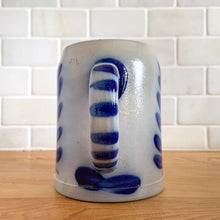 Load image into Gallery viewer, Salt glazed pottery has such a magical quality with its simple decorative style. This stein has a beautiful botanical design in cobalt blue which is striking against the light gray pottery. Crafted by Schilz in Germany. This stein is perfect for a mug of beer or repurpose to hold a small grouping of kitchen utensils or use as a pen/pencil holder. In excellent condition, no chips or cracks. Maker&#39;s mark on the side. Measures 3 3/4 x 5 inches.Capacity 1/2 litre
