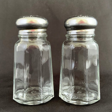 Sail away to flavor-town with this retro vintage set of salt and pepper shakers! These 50s-style Anchor Hocking shakers come with stylish clear pressed glass panels and stainless steel screw-on lids so you can season your food with a real blast from the past! Wooo!  The glass is in excellent condition, free from chips/cracks. The lids have some wear, see photos.  Measures 1 3/8 x 3 inches