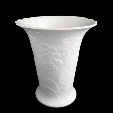 Vintage Sardinia white bisque flower footed trumpet vase features an embossed bouquet of flowers and semi-scalloped rim. Marked 642. Designed by M. Frey for Kaiser, Germany, 1980s. This delicate vase will look stunning in any setting!

In excellent condition, no chips/cracks/repairs. Maker's mark on bottom.

Measures 5 5/8 x 5 3/4 x 6 1/4 inches