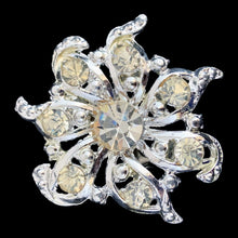 Load image into Gallery viewer, Vintage silver-tone pinwheel rhinestone brooch, large central faceted stone with swirling openwork scrollwork arms, front view
