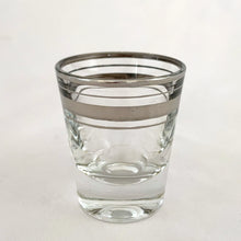 Load image into Gallery viewer, Set of six vintage mid-century era silver banded and rimmed shot glasses. Libbey Glass, USA, 1960s. Add some Hollywood Regency glam to your barware collection with these beauties!

Good vintage condition, no chips, minor wear to the silver.

Measures 1 7/8 x 2 1/4 inches

Capacity 1 ounce
