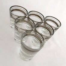 Load image into Gallery viewer, Set of six vintage mid-century era silver banded and rimmed shot glasses. Libbey Glass, USA, 1960s. Add some Hollywood Regency glam to your barware collection with these beauties!

Good vintage condition, no chips, minor wear to the silver.

Measures 1 7/8 x 2 1/4 inches

Capacity 1 ounce
