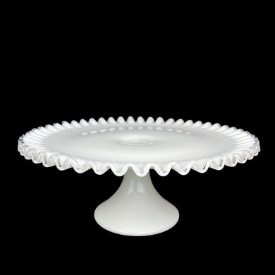 This vintage milk glass Silver Crest round cake stand features a classic clear crimped edge. Crafted by Fenton Art Glass, USA, between 1942 - 1986. A stunning example of mid-century tableware that will always be in style no matter your decor style! An elegant way to present cakes and desserts whether for everyday entertaining, a wedding or bridal shower!

In excellent condition, no chips. Unmarked.

Measures 13 x 5 inches