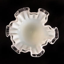 Load image into Gallery viewer, A classic piece of glass artistry, this vintage &quot;Silver Crest&quot; footed milk glass bud vase features a clear double crimped edge. Crafted by Fenton Art Glass, USA, pre-1970.  An elegant and charming piece that will be enjoyed for years to come.  In excellent condition, free from chips. Unmarked, pre-1970.  Measures approximately 4 1/2 x 4 1/8 inches
