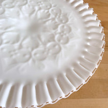 Load image into Gallery viewer, This vintage milk glass &quot;Silver Crest Spanish Lace&quot; round cake stand features a classic clear crimped edge and a raised hearts and swirls design. Crafted by the Fenton Art Glass, USA, between 1942 - 1969. A stunning example of mid-century tableware that will always be in style no matter your decor style! An elegant way to present cakes and desserts whether for everyday entertaining, a wedding or bridal shower! In excellent condition, free from chips. Unmarked. Measures 11 x 4 1/2 inches
