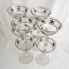 Load image into Gallery viewer, These vintage mid-century glasses certainly put the &quot;glam&quot; in glamourous. The pattern is called  &quot;Silver Leaf&quot; which is a band of silver leaves set on a frosted band on glass bordered by more silver. The stem replicates a delicate grecian style column. These will make a stunning addition to your barware!  Produced by the Libbey Glass Company in the USA, produced between 1953 - 1978.  In excellent condition, free form chips/cracks/wear.   Measures 3-3/4&quot; x 5-5/8&quot;
