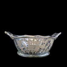 Load image into Gallery viewer, A lovely octagon shaped clear glass handled bowl featuring an art deco style decorative silver overlay of floral swags. The perfect size for candies or nuts and is easily repurposed as a trinket dish.   In excellent condition, free from chips/cracks and the silver overlay is intact.  Measures 6 5/8 x 3 1/8 inches (incl. handles)
