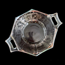 Load image into Gallery viewer, A lovely octagon shaped clear glass handled bowl featuring an art deco style decorative silver overlay of floral swags. The perfect size for candies or nuts and is easily repurposed as a trinket dish.   In excellent condition, free from chips/cracks and the silver overlay is intact.  Measures 6 5/8 x 3 1/8 inches (incl. handles)
