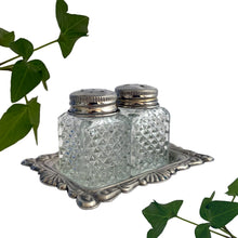 Load image into Gallery viewer, Vintage diamond pattern cut glass salt and pepper shakers with silver plate lids and tray. Crafted in Hong Kong, circa 1960s. A sweet set for your tablescape! In excellent vintage condition. Shakers measure 1 x 1 x 1 3/4 inches. Tray measures 3 1/8 x 2 3/8 inches.
