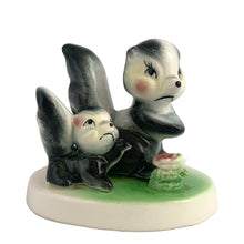 Load image into Gallery viewer, Vintage mid-century kitsch ceramic figures of a skunk mama and baby with a sweet pink flower on a stand. Crafted in Japan, circa 1950s. An adorable figurine to add to your mid-century animal figurine collection.  In excellent condition, no chips/cracks/repairs.  Measures 3 1/2 x 2 5/8 x 3 inches
