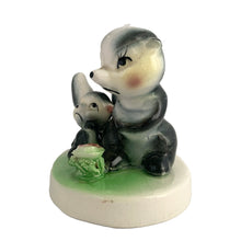 Load image into Gallery viewer, Vintage mid-century kitsch ceramic figures of a skunk mama and baby with a sweet pink flower on a stand. Crafted in Japan, circa 1950s. An adorable figurine to add to your mid-century animal figurine collection.  In excellent condition, no chips/cracks/repairs.  Measures 3 1/2 x 2 5/8 x 3 inches
