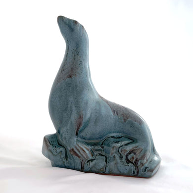 Vintage seal perched on rocks redware figurine, finished in slate blue drip glaze with a matte finish. Crafted by Blue Mountain Pottery, Canada, circa 1970s. A beautiful and highly collectible piece of pottery from this iconic brand! Excellent condition, free from chips/cracks/repairs. Measures 5 3/4 x 4 x 7 1/2 inches