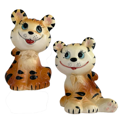 Vintage anthropomorphic smiling tiger ceramic salt and pepper shakers with ribbon collars. Crafted in Japan and imported by Enterprise. These adorable shakers will make a wonderful addition to your kitsch collection and kitchen decor!  In excellent condition, free from chips/cracks/repairs. Enterprise sticker and plastic stoppers present.  Measures 2 3/8 x 1 7/8 x 4 inches