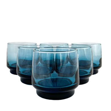 Adorn your table with this timeless set of 8 smokey blue rocks glass tumblers. Crafted by Dominion Glass, Canada, in the 1970s. These elegant glasses will add a vintage touch to any gathering. Enjoy a classic toast with a stunningly beautiful drinkware set!  In excellent condition, free from chips.  Measures 3 x 2 3/4 inches  Capacity 6 ounces
