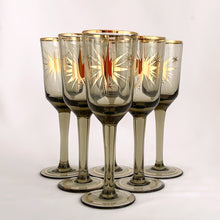 Load image into Gallery viewer, Gorgeous set of six vintage mid-century modern smokey brown liquor glasses decorated with atomic gold stars and rims.  In excellent condition, free from chips/wear.  Measures 1 3/4 x 5 1/8 inchesGorgeous set of six vintage mid-century modern smokey brown liquor glasses decorated with atomic gold stars and rims.  In excellent condition, free from chips/wear.  Measures 1 3/4 x 5 1/8 inches
