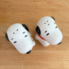 Load image into Gallery viewer, Vintage retro Snoopy character ceramic salt and pepper shakers with plastic stoppers. B&amp;M Inc., Taiwan, 1970s. Add these adorable and highly collectible shakers to your collection!

In excellent vintage condition, no chips/cracks/repairs. Maker&#39;s mark and sticker.

Measures 2 1/4 x 2 3/4 x 3 3/4 inches
