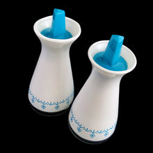 Load image into Gallery viewer, This is a pair of vintage PYREX oil and vinegar white cruets featuring the &quot;Snowflake Garland&quot; pattern in white on turquoise with matching lids. Crafted by Corning Glass, USA, 1972 - 1975.&nbsp;These look brand spanking new and will make&nbsp;a great addition to your tablescape or PYREX collection!  Both the glass and plastic tops are in excellent condition, no chips/wear.  Measures 2 x 4 1/2 inches
