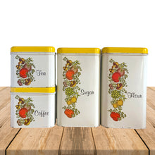 Load image into Gallery viewer, Vintage &quot;Spice of Life&quot; four piece metal stackable kitchen canister set featuring white canisters with yellow lids and the distinctive vegetables of this pattern. Each has period style typography in black printed letters flour, sugar, coffee and tea. Crafted by J. Chein &amp; Co., USA, circa 1960s. Perfect for the retro kitchen enthusiast! 
