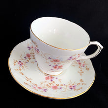 Load image into Gallery viewer, Vintage Spinney white bone china teacup and saucer features pink, purple and gold florals, trimmed in gold gilt. Crafted by Duchess, England, 1960s. A lovely way to enjoy a cuppa tea!

In excellent condition, no chips, cracks or repairs. Maker&#39;s mark on the bottom.

Measures 3 7/8 x 2 3/4 x 5 1/2 inches
