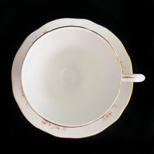 Load image into Gallery viewer, Vintage Spinney white bone china teacup and saucer features pink, purple and gold florals, trimmed in gold gilt. Crafted by Duchess, England, 1960s. A lovely way to enjoy a cuppa tea!

In excellent condition, no chips, cracks or repairs. Maker&#39;s mark on the bottom.

Measures 3 7/8 x 2 3/4 x 5 1/2 inches
