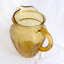 Load image into Gallery viewer, This vintage &quot;Sprucewood Honey Gold&quot; ice lip pressed glass pitcher features a paneled shape with a bark-like design. Crafted by Anchor Hocking, USA, circa 1970s. A great addition to your tablescape or barware!  In excellent condition, free from chips.  Measures 5 1/2 x 8 inches  Capacity 86 ounces
