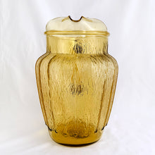 Load image into Gallery viewer, This vintage &quot;Sprucewood Honey Gold&quot; ice lip pressed glass pitcher features a paneled shape with a bark-like design. Crafted by Anchor Hocking, USA, circa 1970s. A great addition to your tablescape or barware!  In excellent condition, free from chips.  Measures 5 1/2 x 8 inches  Capacity 86 ounces
