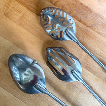Load image into Gallery viewer, Scraper slotted spoon from the Skyline set showing angled edge designed to reach corners of pots and pans
