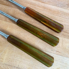 Load image into Gallery viewer, Close-up of the marbled Bakelite handles showing amber, green, and yellow swirl pattern on the Skyline spoon set
