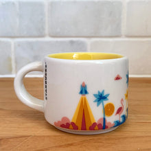 Load image into Gallery viewer, This sweet Starbucks collectible &quot;FLORIDA&quot; mini ceramic mug Christmas ornament from the &quot;You Are Here&quot; Collection, 2016. This white mug features a graphic skyline design in shades of yellow, orange and blue with yellow interior. Celebrate the sunshine state with an espresso!

In excellent condition, free from chips/cracks/wear.

Measures 2 3/8 x 1 7/8 inches

Capacity 2 ounces
