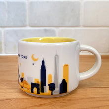 Load image into Gallery viewer, This sweet Starbucks collectible NEW YORK mini ceramic mug Christmas ornament from the You Are Here Collection, 2016. This white mug features a graphic skyline design in shades of yellow, orange and blue with yellow interior. Celebrate the Empire State with an espresso!

In excellent condition, free from chips/cracks/wear.

Measures 2 3/8 x 1 7/8 inches

Capacity 2 ounces
