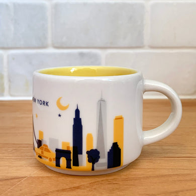 This sweet Starbucks collectible NEW YORK mini ceramic mug Christmas ornament from the You Are Here Collection, 2016. This white mug features a graphic skyline design in shades of yellow, orange and blue with yellow interior. Celebrate the Empire State with an espresso!

In excellent condition, free from chips/cracks/wear.

Measures 2 3/8 x 1 7/8 inches

Capacity 2 ounces