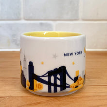 Load image into Gallery viewer, This sweet Starbucks collectible NEW YORK mini ceramic mug Christmas ornament from the You Are Here Collection, 2016. This white mug features a graphic skyline design in shades of yellow, orange and blue with yellow interior. Celebrate the Empire State with an espresso!

In excellent condition, free from chips/cracks/wear.

Measures 2 3/8 x 1 7/8 inches

Capacity 2 ounces
