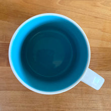 Load image into Gallery viewer, Perfect for your morning cuppa joe to make you feel like a world traveller! This fabulous collectible VANCOUVER ceramic mug was produced by Starbucks as part of their YOU ARE HERE collection, 2014. A white ceramic mug printed design in shades of green blue, brown and red with blue interior. Celebrate the By Sea, Land, and Air We Prosper city!

In excellent condition, free from chips/cracks/wear.

Measures 3 5/8 x 3 3/8 inches

Capacity 14 ounces
