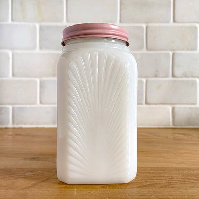 Vintage milk glass shaker featuring an pressed starburst pattern. Produced by McKee Glass, circa 1950. Beautiful art deco design to add to your shaker collection and tableware.  In excellent condition, free from chips. Metal lid may have been repainted.  2 3/8 x 2 3/8 x 4 1/2 inches