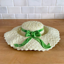 Load image into Gallery viewer, Delightful vintage pale yellow straw hat with green bow ceramic posy vase. Crafted by Falcon Ware, England, 1940s. Fill will flowers to create a charming floral centrepiece.

In excellent condition, no chips/cracks/repairs.

Measures 8 1/2 x 2 1/4 inches

