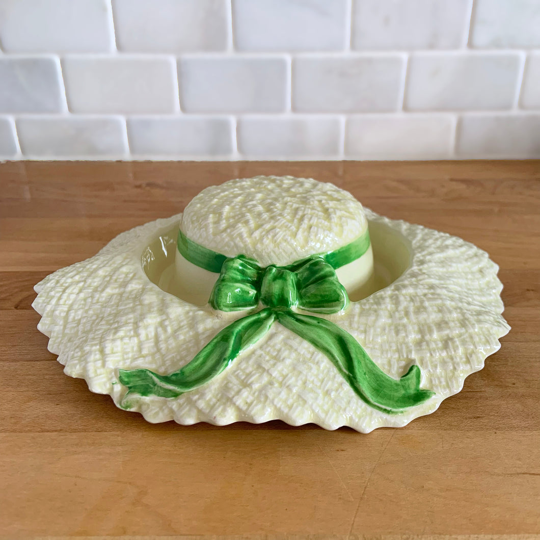 Delightful vintage pale yellow straw hat with green bow ceramic posy vase. Crafted by Falcon Ware, England, 1940s. Fill will flowers to create a charming floral centrepiece.

In excellent condition, no chips/cracks/repairs.

Measures 8 1/2 x 2 1/4 inches