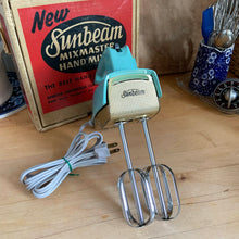 Load image into Gallery viewer, Fabulous vintage turquoise and gold Sunbeam Mixmaster hand mixer. Crafted by the Sunbeam Corporation, Canada, 1957. The mixer is in the original box with 2 beaters and instruction/recipe booklet and has the original packing slip on the outside of the box in an envelope. A must-have for any baker or appliance collector! Tested. In good working order.

