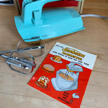 Load image into Gallery viewer, Fabulous vintage turquoise and gold Sunbeam Mixmaster hand mixer. Crafted by the Sunbeam Corporation, Canada, 1957. The mixer is in the original box with 2 beaters and instruction/recipe booklet and has the original packing slip on the outside of the box in an envelope. A must-have for any baker or appliance collector! Tested. In good working order.
