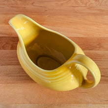 Load image into Gallery viewer, Fiestaware &quot;Sunflower&quot; yellow handled gravy sauceboat. The style and durability of this restaurantware can&#39;t be beat! Produced by the Homer Laughlin Company, USA, from 2001-. Dishwasher, oven and microwave safe and the great thing about the newer production is it is lead-free!  In excellent condition, free from chips/cracks. Marked on the bottom.  Measures 8 x 4 1/8 x 4 3/5 inches  Capacity 8 1/2 ounces
