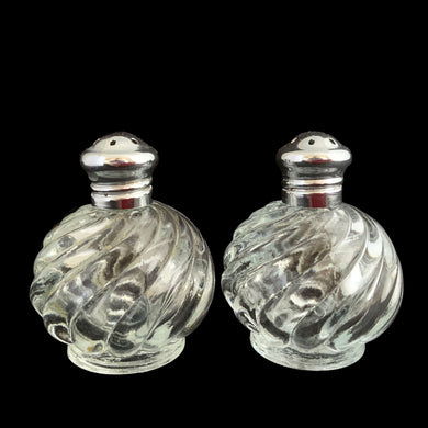 Enhance your tablescape with these vintage round swirl glass salt and peppers shakers topped with steel lids....so charming! In excellent condition, free from chips. Marked 