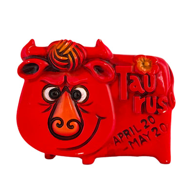 Adorable vintage zodiac sign ceramic coin bank of a grinning bull representing the astrological sign of Taurus. The bull is painted red with embossed features including the word 