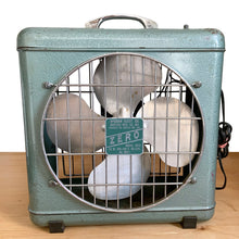Load image into Gallery viewer, Full front view of vintage ZERO Model 4010 box fan on hardwood floor, teal enamel body, chrome carry handle, four-blade fan visible through wire grille, McGraw Electric Co. data plate reading 55W 105–120V 60 CYC AC Only
