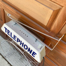 Load image into Gallery viewer, Fabulous find!!! Vintage electric lighted telephone sign with metal wall bracket for ease of hanging. The cobalt blue raised lettering is molded white plastic. Crafted by Brouillette Signs Ltc. Montreal Canada, circa 1940s. This sign was sourced from the estate of the Dale family pharmacy in downtown Toronto Canada. A great piece of Canadian advertising craftsmanship.
