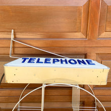 Load image into Gallery viewer, Fabulous find!!! Vintage electric lighted telephone sign with metal wall bracket for ease of hanging. The cobalt blue raised lettering is molded white plastic. Crafted by Brouillette Signs Ltc. Montreal Canada, circa 1940s. This sign was sourced from the estate of the Dale family pharmacy in downtown Toronto Canada. A great piece of Canadian advertising craftsmanship.
