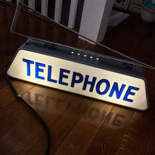 Load image into Gallery viewer, Fabulous find!!! Vintage electric lighted telephone sign with metal wall bracket for ease of hanging. The cobalt blue raised lettering is molded white plastic. Crafted by Brouillette Signs Ltc. Montreal Canada, circa 1940s. This sign was sourced from the estate of the Dale family pharmacy in downtown Toronto Canada. A great piece of Canadian advertising craftsmanship.
